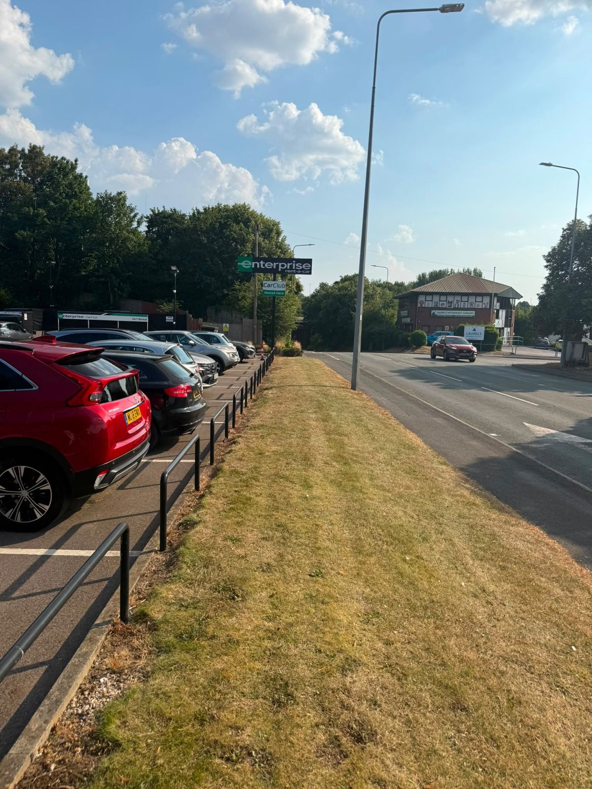 Mown grass verge along a car park and roadside
